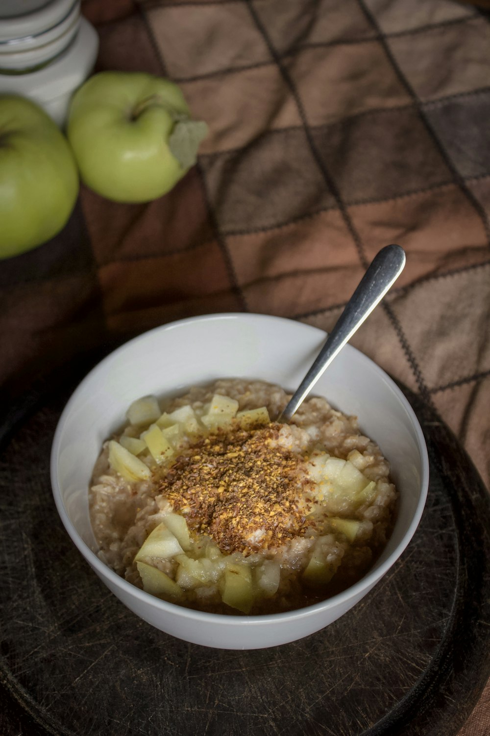 bowl of oatmeal topped with chopped green apples