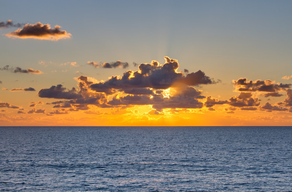 sea under cloudy sky during golden hour