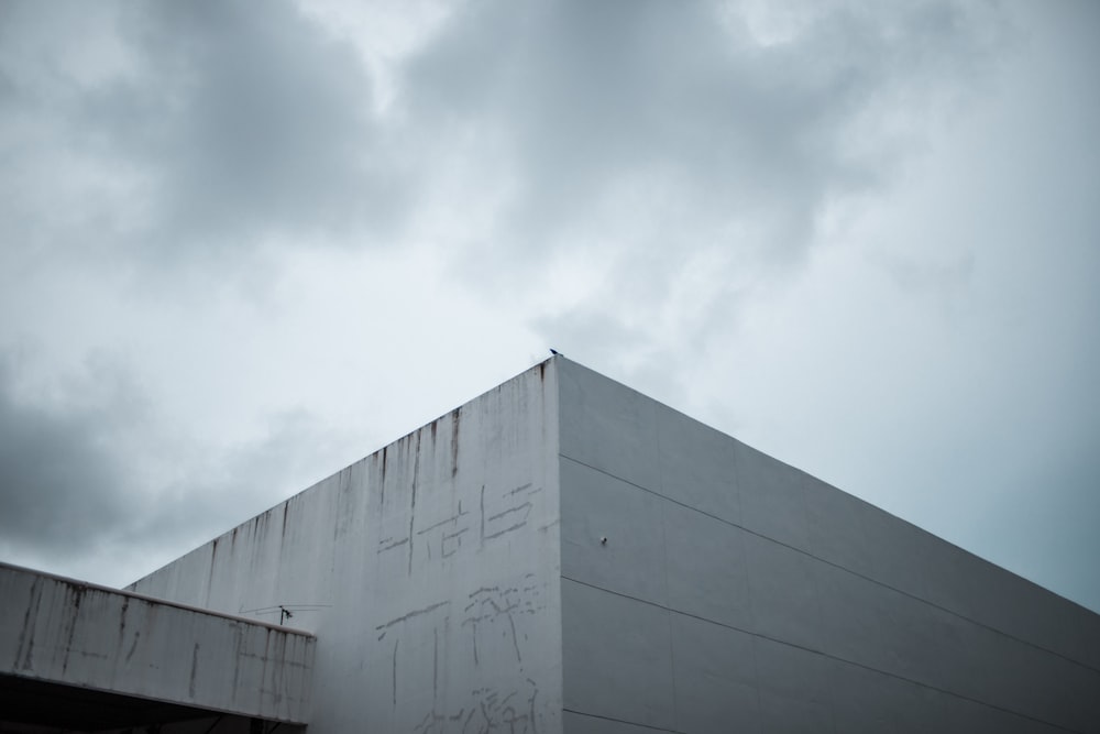 a white building with graffiti on it under a cloudy sky