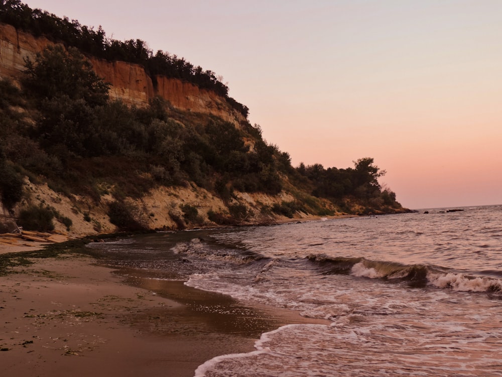 a beach with a cliff in the background