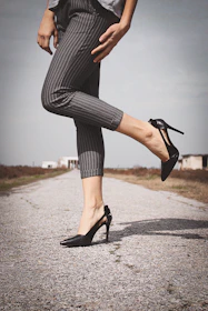 woman standing while wearing black leather heeled sandals
