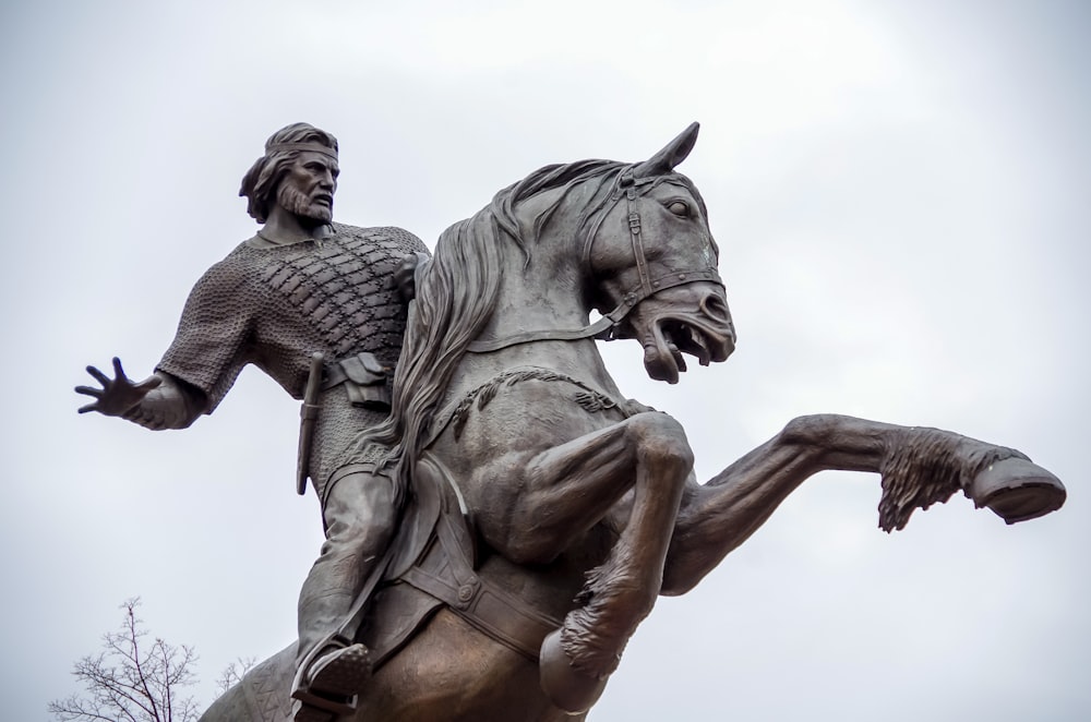 Photographie sélective de l’homme montant à cheval statue