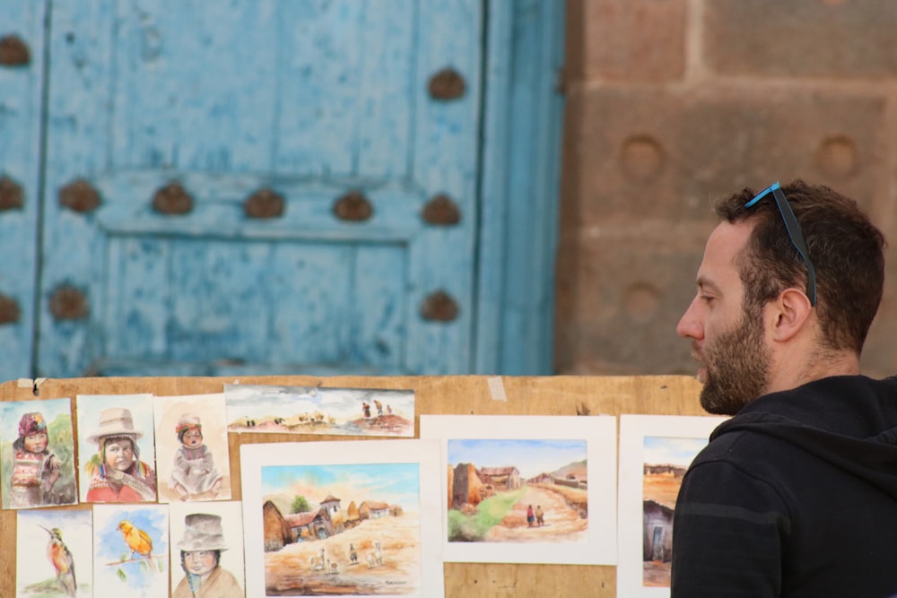 a man sitting in front of a table with pictures on it