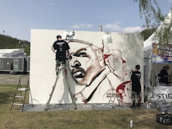 An artist painting a mural in an urban setting, full of energy