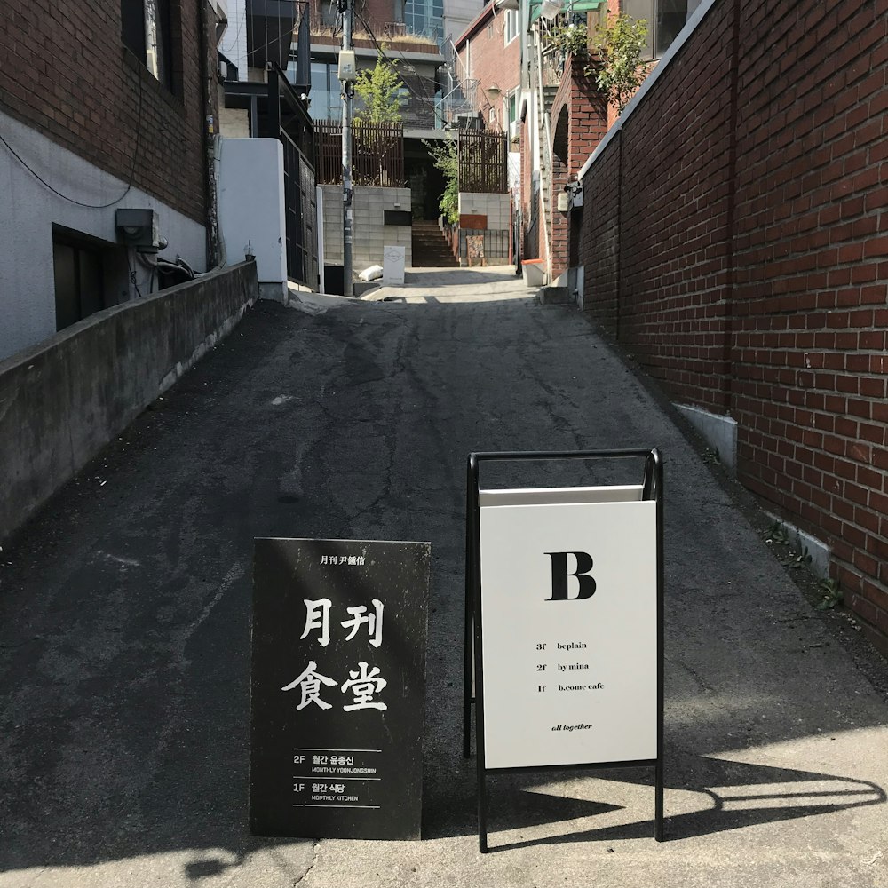 black and white road signs between buildings