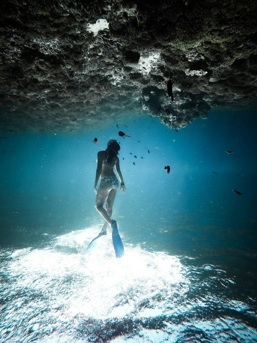 woman underwater wearing blue flippers