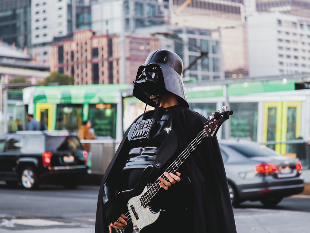 person in Darth Vader costume holding guitar