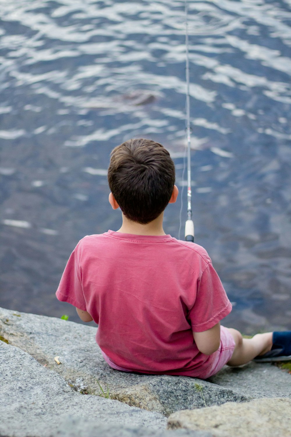 boy fishing on body of water