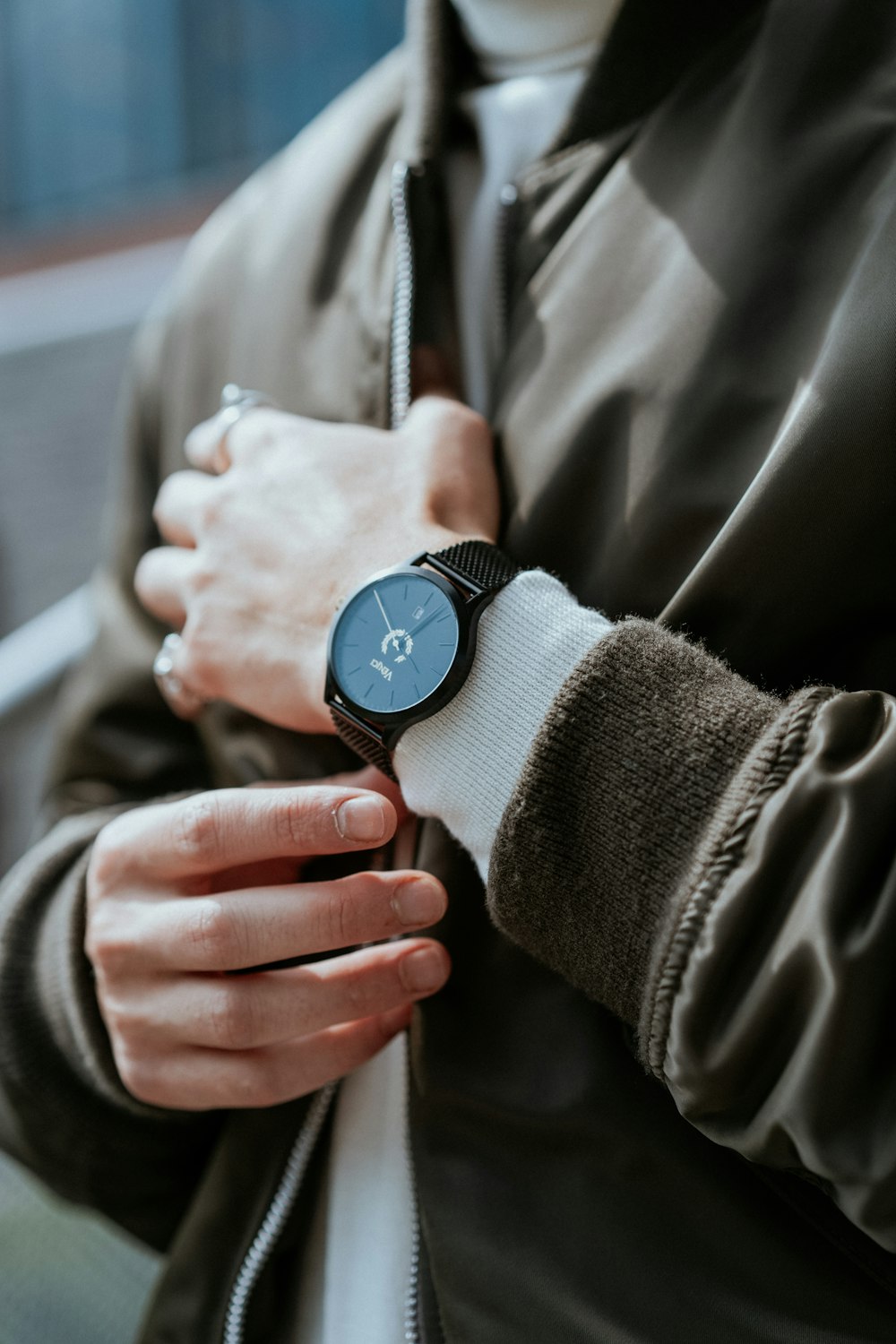 man standing while wearing round black analog watch