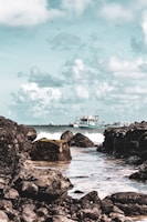 vessel on body of water under cloudy sky