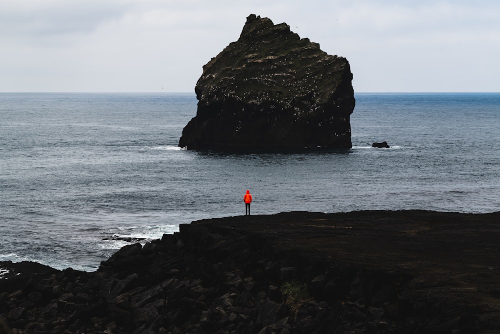 person standing in front of rock formation