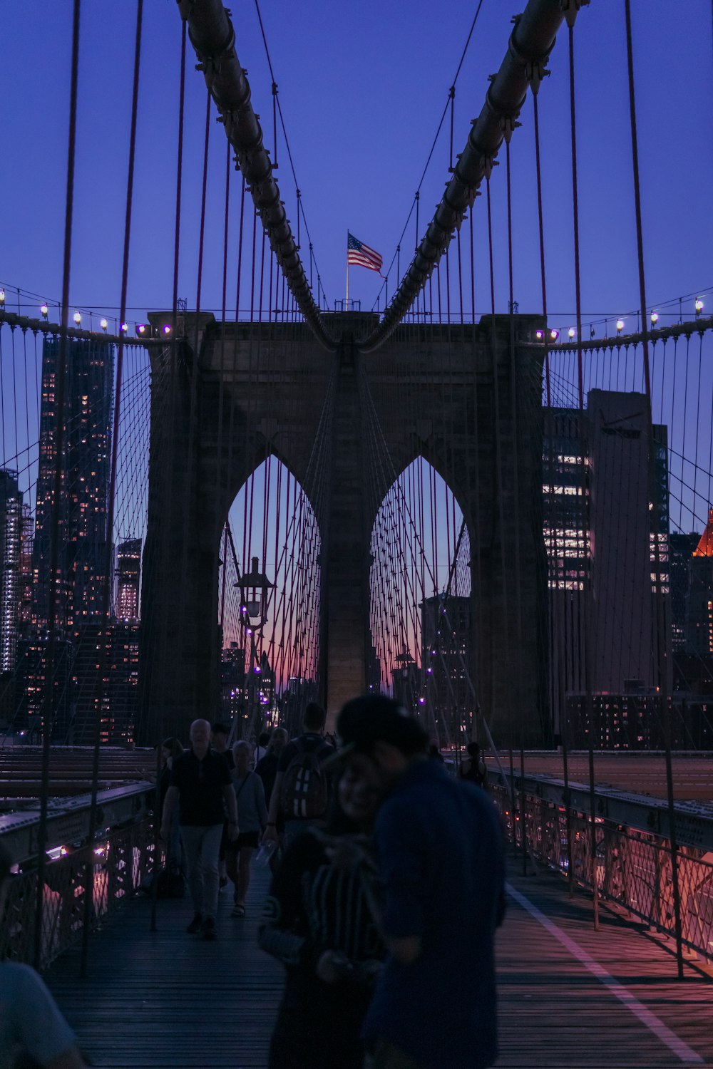 a group of people walking across a bridge