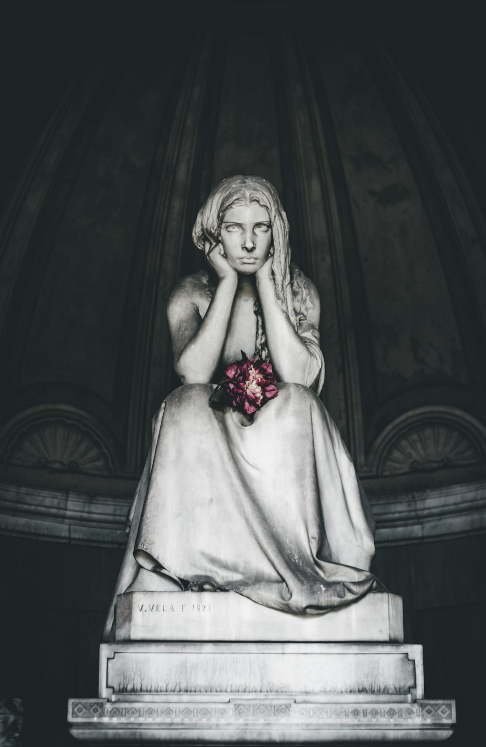 woman sitting head resting on hands statue