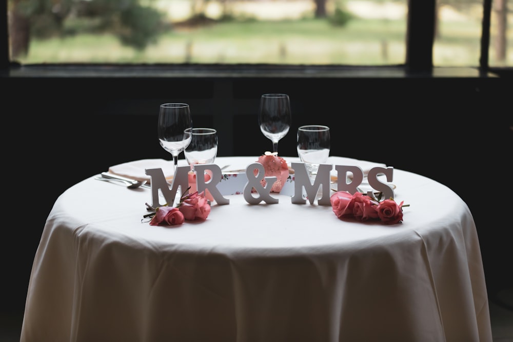 Lettera autoportante Mr & Mrs sul tavolo con quattro bicchieri da vino