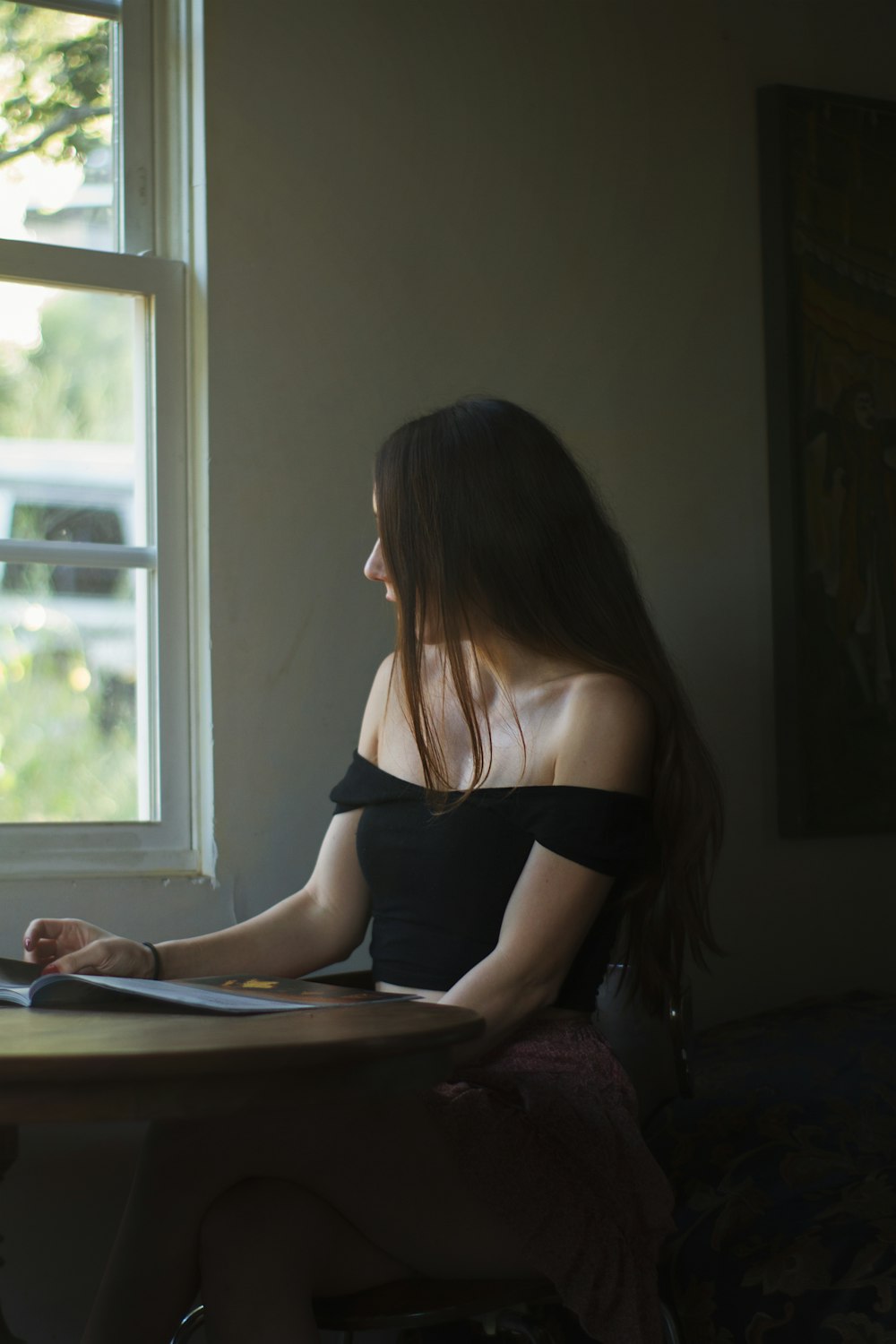 woman sitting on chair beside window