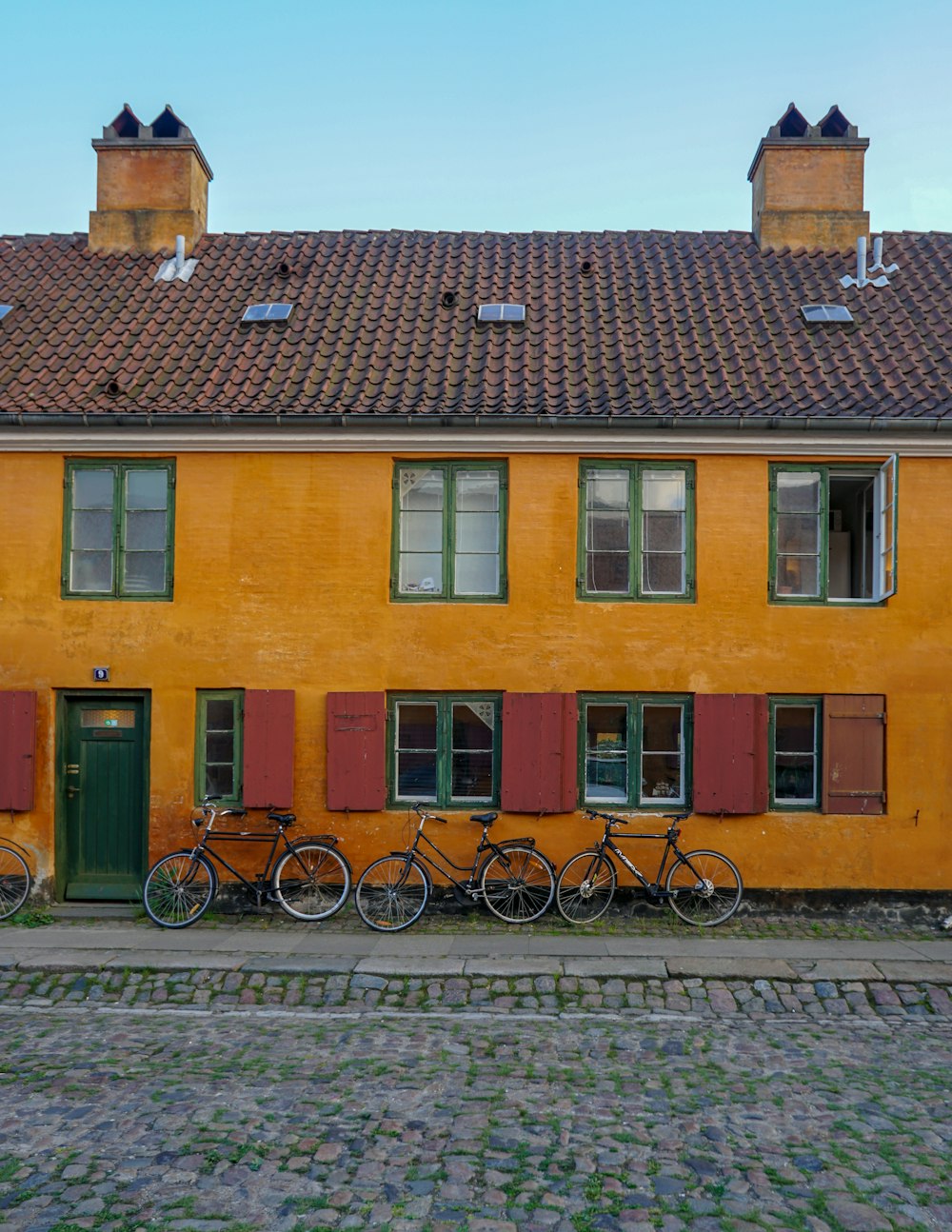 three bicycle leaning on house