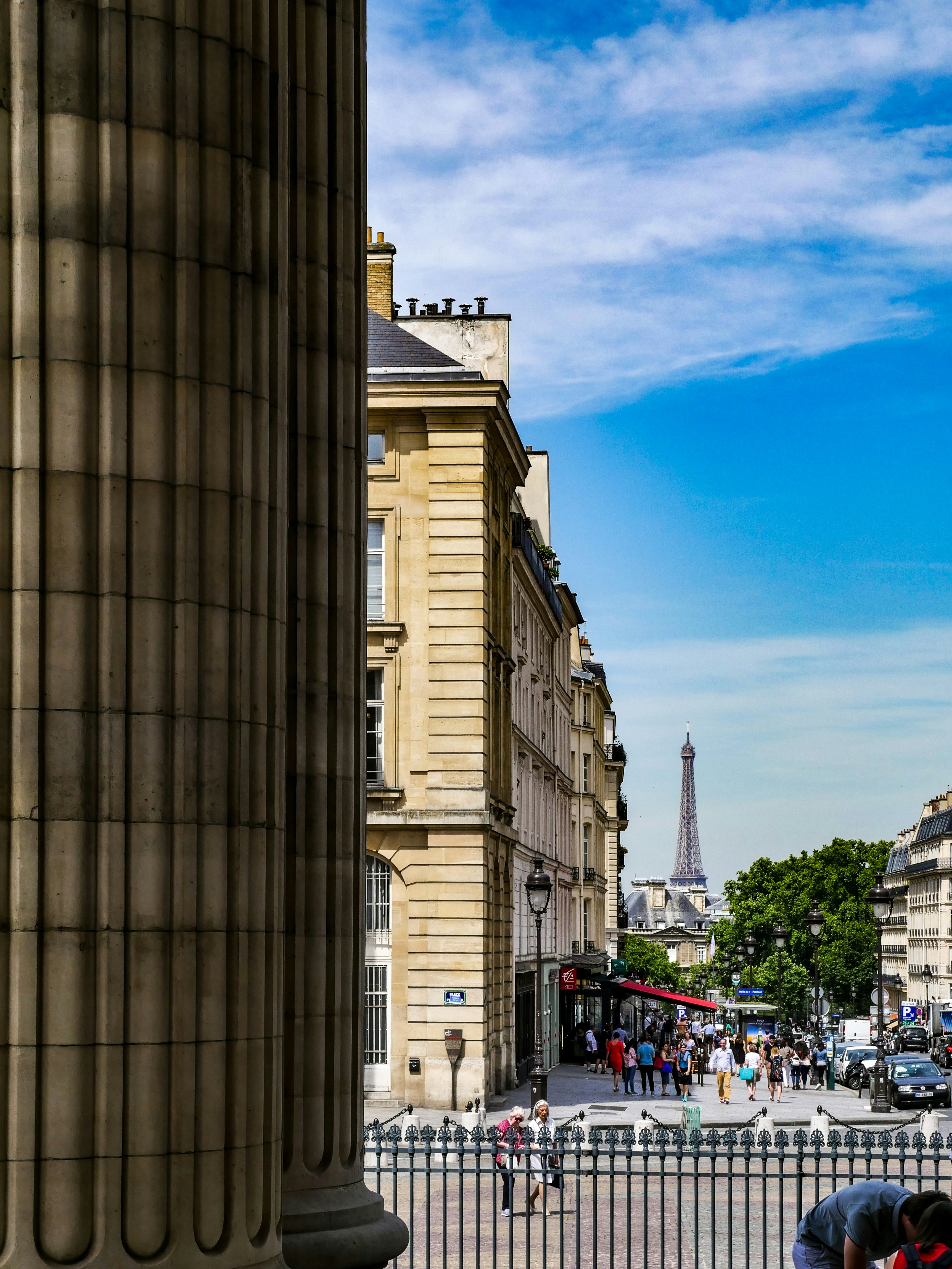 Un grupo de personas caminando por una calle junto a edificios altos