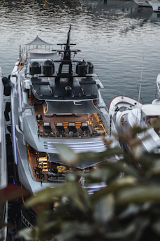 Marine engineer reviewing battery system designs on a tablet near a docked yacht