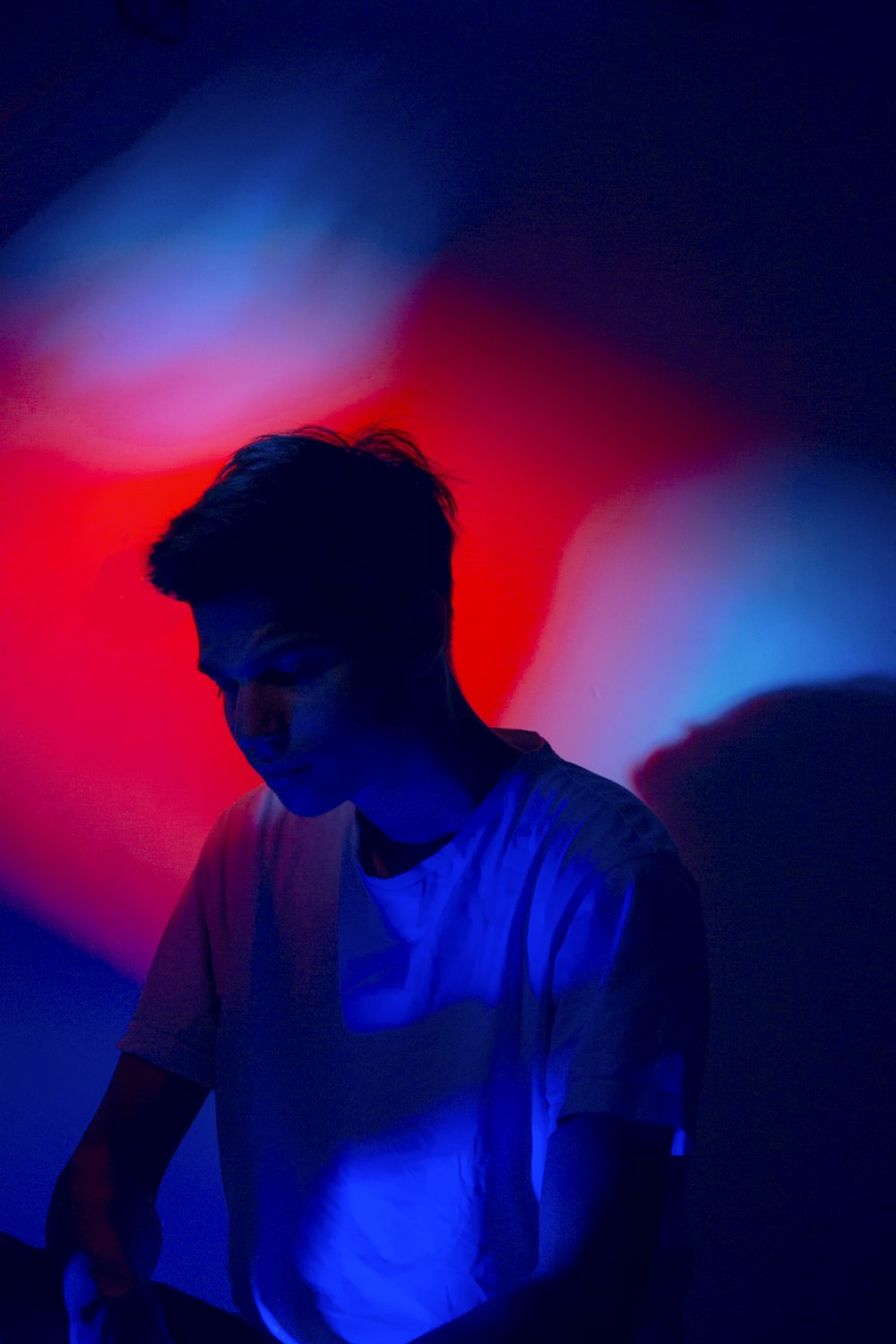 Foto de hombre con camisa blanca con fondo de luz roja y azul