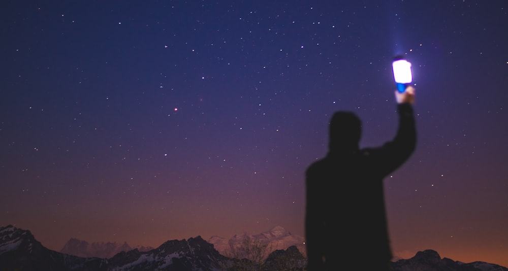 silhouette of person holding smartphone