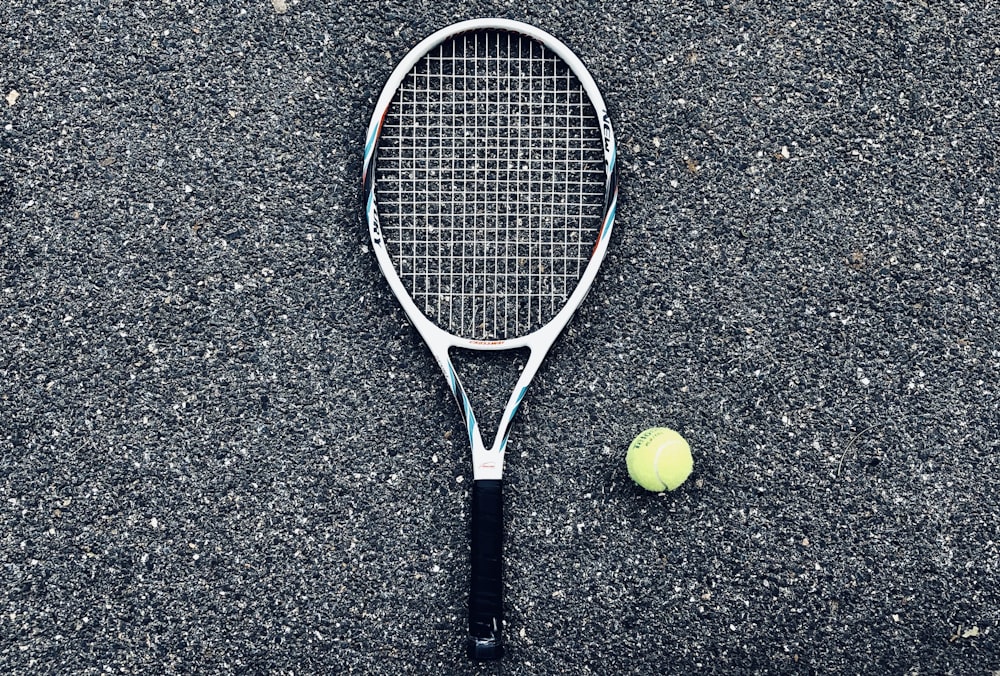 white tennis racket and green tennis ball