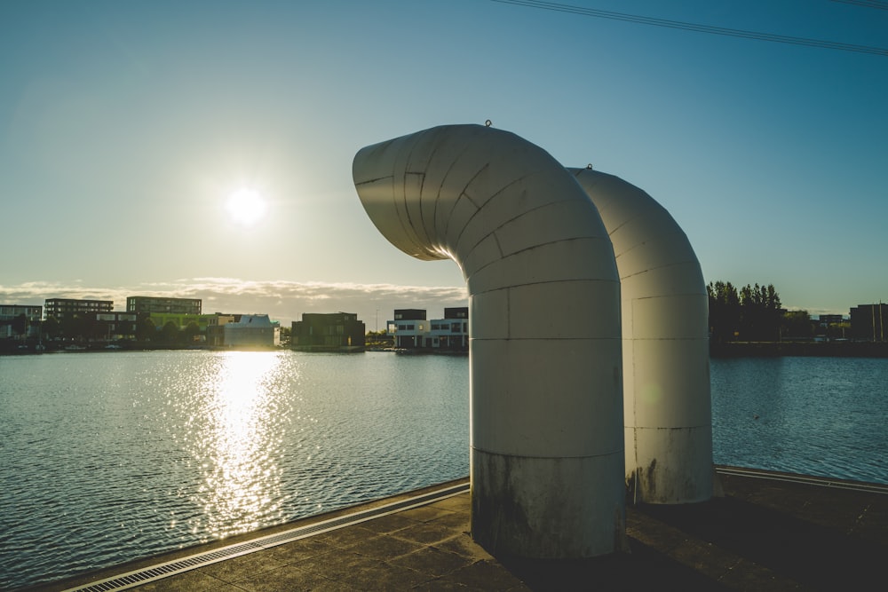 two white exhaust pipes photo across body of water