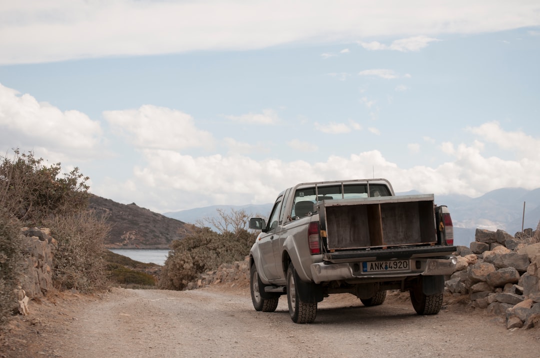 gray pickup truck on sand pathway