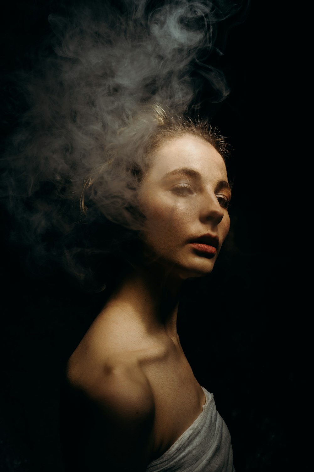 female model in a white top and smoke
