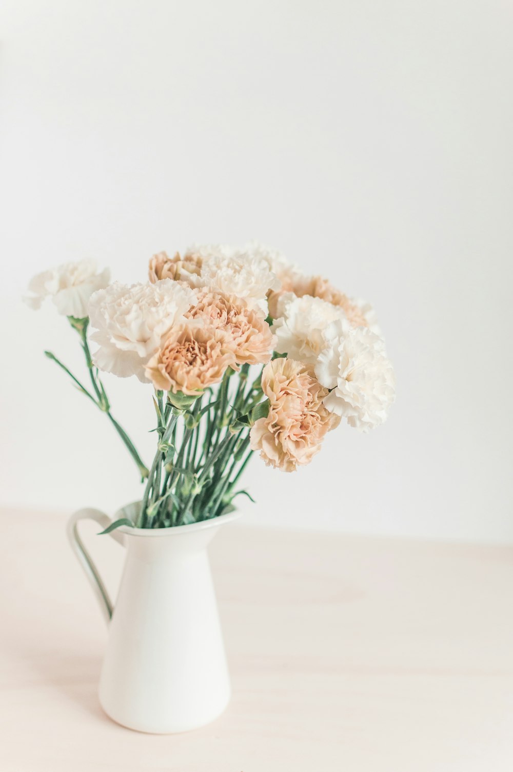 flores blancas y beige en una jarra blanca