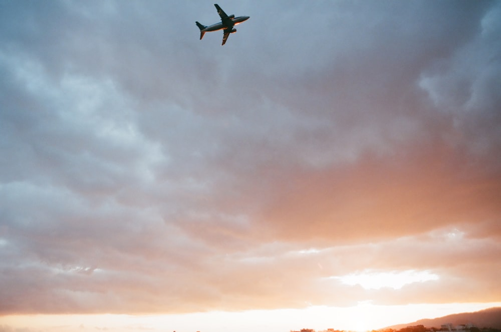 white airplane on flight at sunset