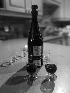 A sophisticated tasting setup with multiple glasses of rum lined up on a polished wooden table.