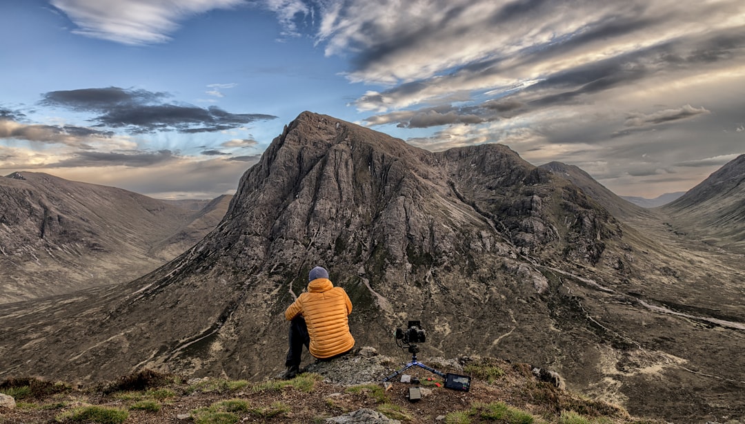 person sitting near rock formation during daytime