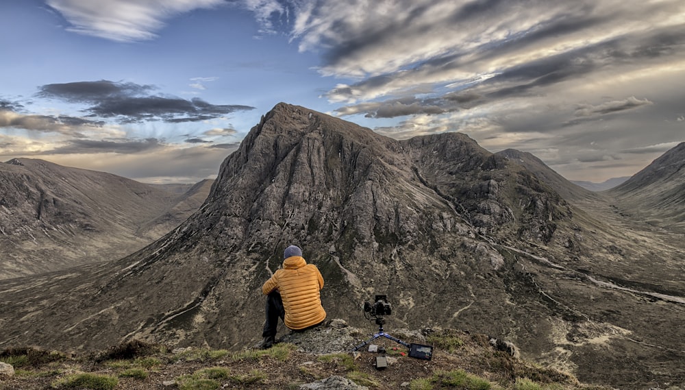 person sitting near rock formation during daytime