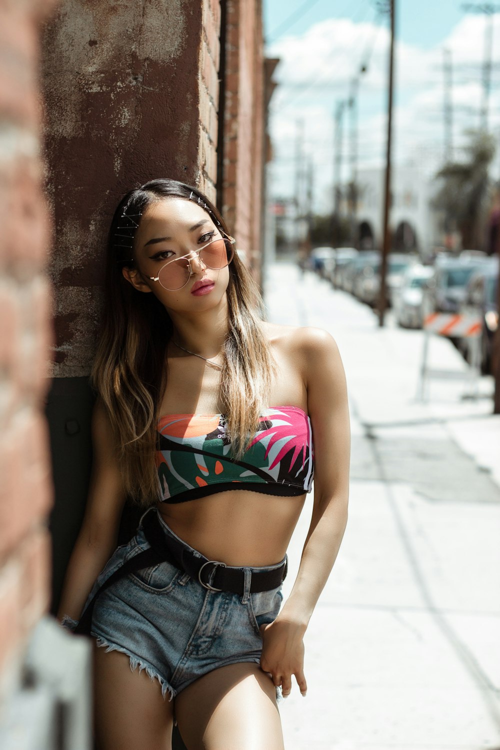 woman wearing blue faded denim short and multicolored crop top