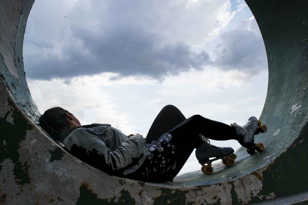 person wearing white roller skates laying on concrete surface