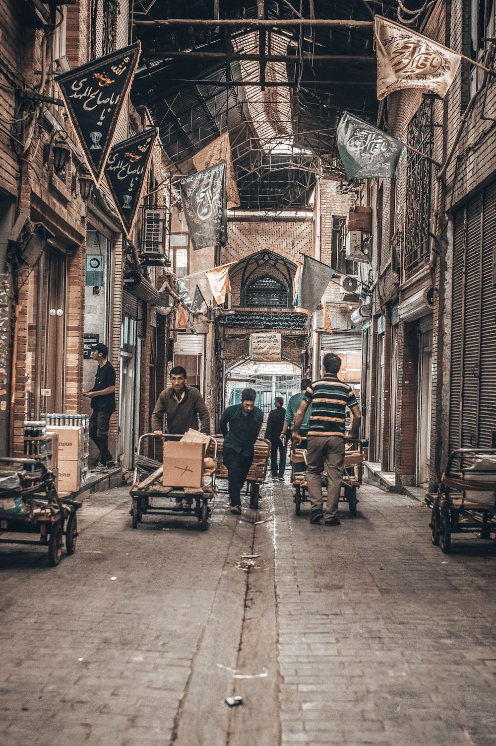 a group of people walking down a street next to tall buildings