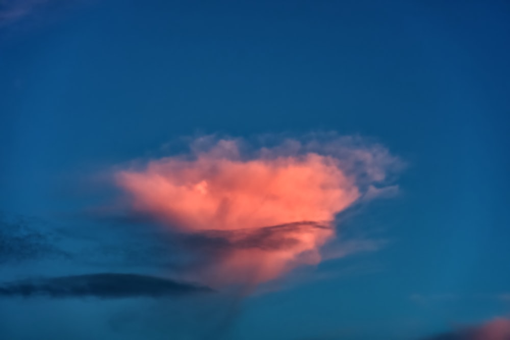 a pink cloud in a blue sky