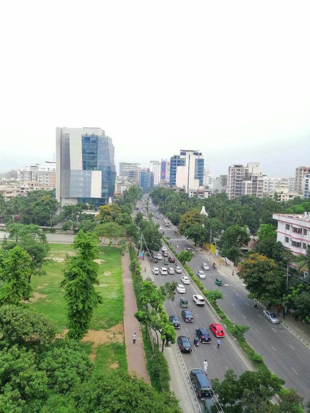 vehicle on road facing buildings under graay sky