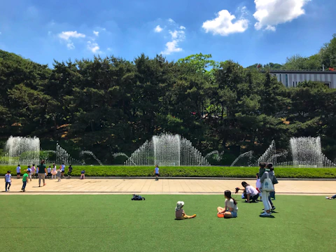 Parents and children enjoying a community sports event in a sunny park.