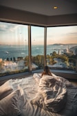 woman lying on bed facing on body of water