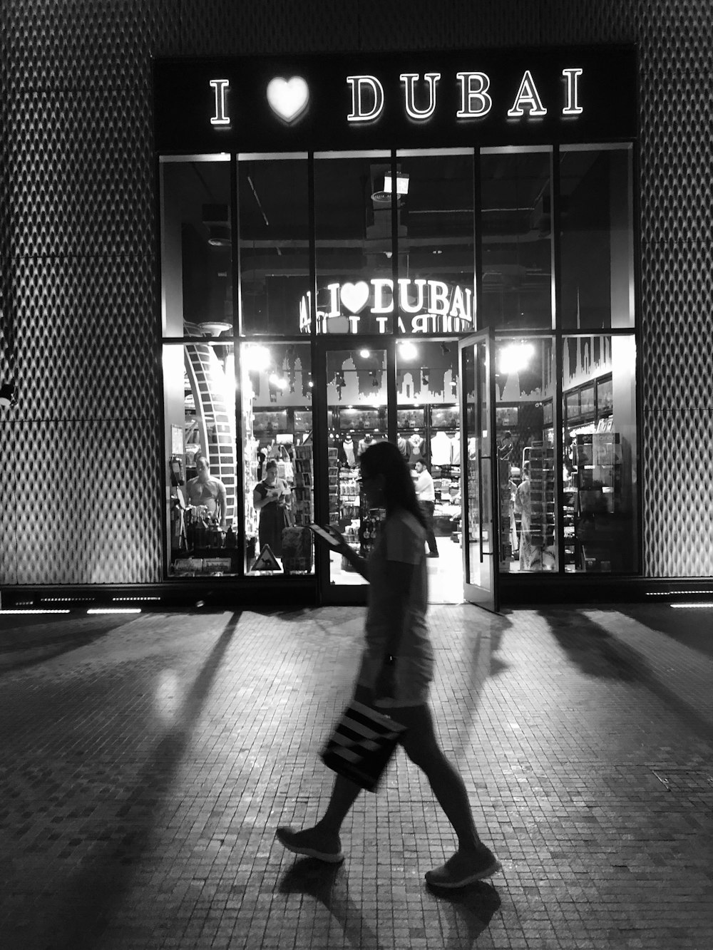 grayscale photo of woman in front of I heart Dubai