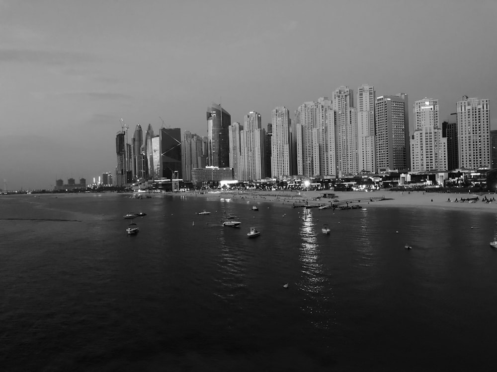 grayscale photography of city buildings beside beach