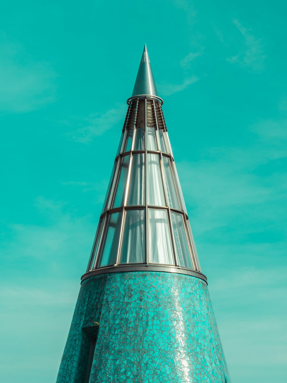 photo of pointed tower across blue sky