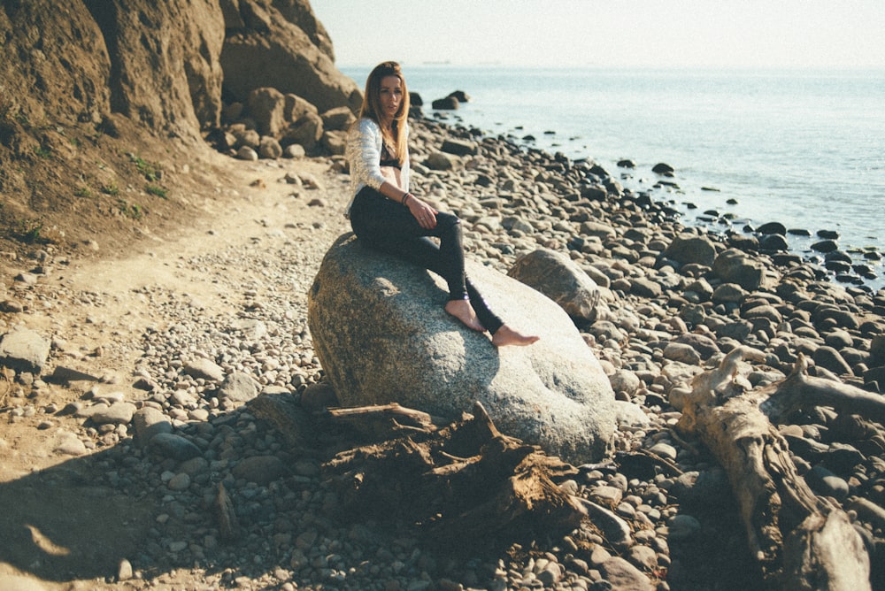 woman sitting on rock