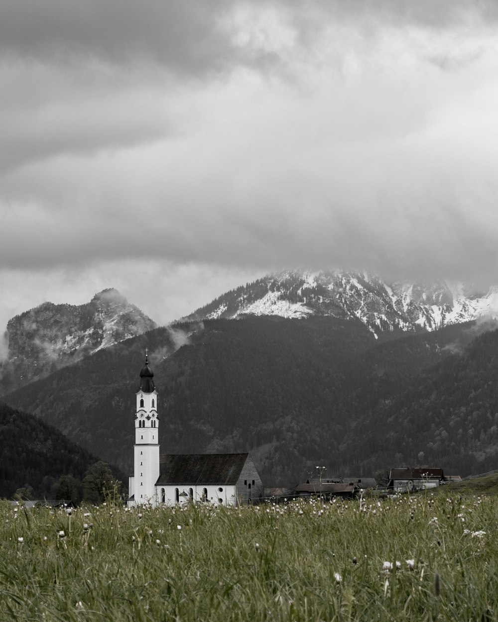 white and gray concrete building with tower beside mountain during daytime