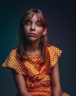 girl in orange and white polka-dot dress smiling