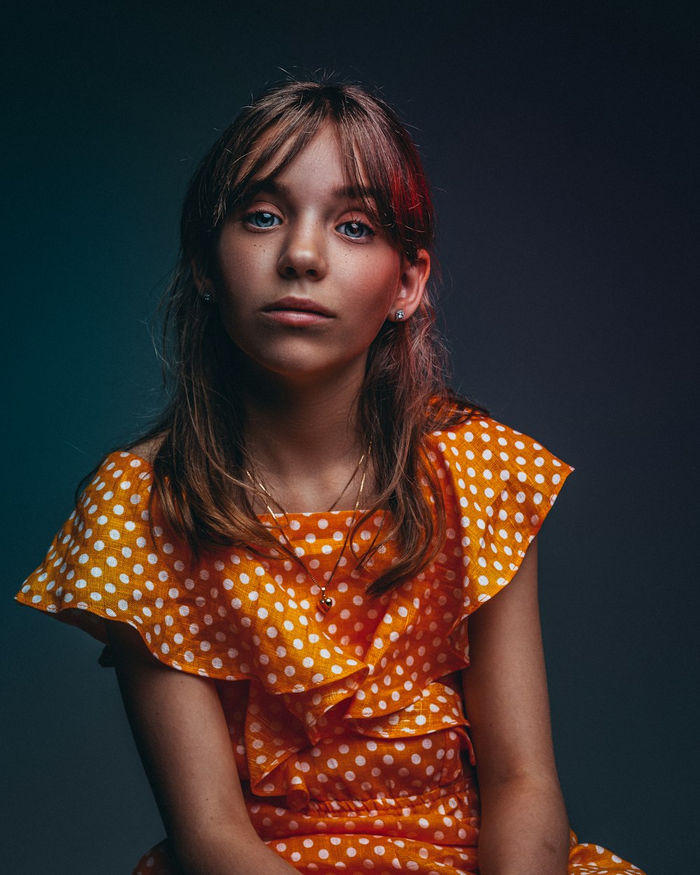 girl in orange and white polka-dot dress smiling