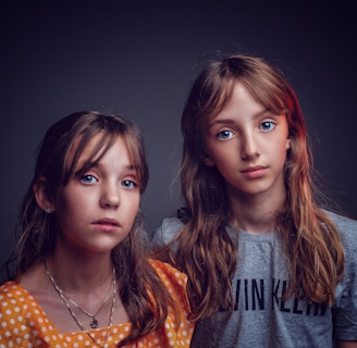 two girls in shirts posing for photo