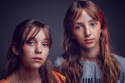 two girls in shirts posing for photo