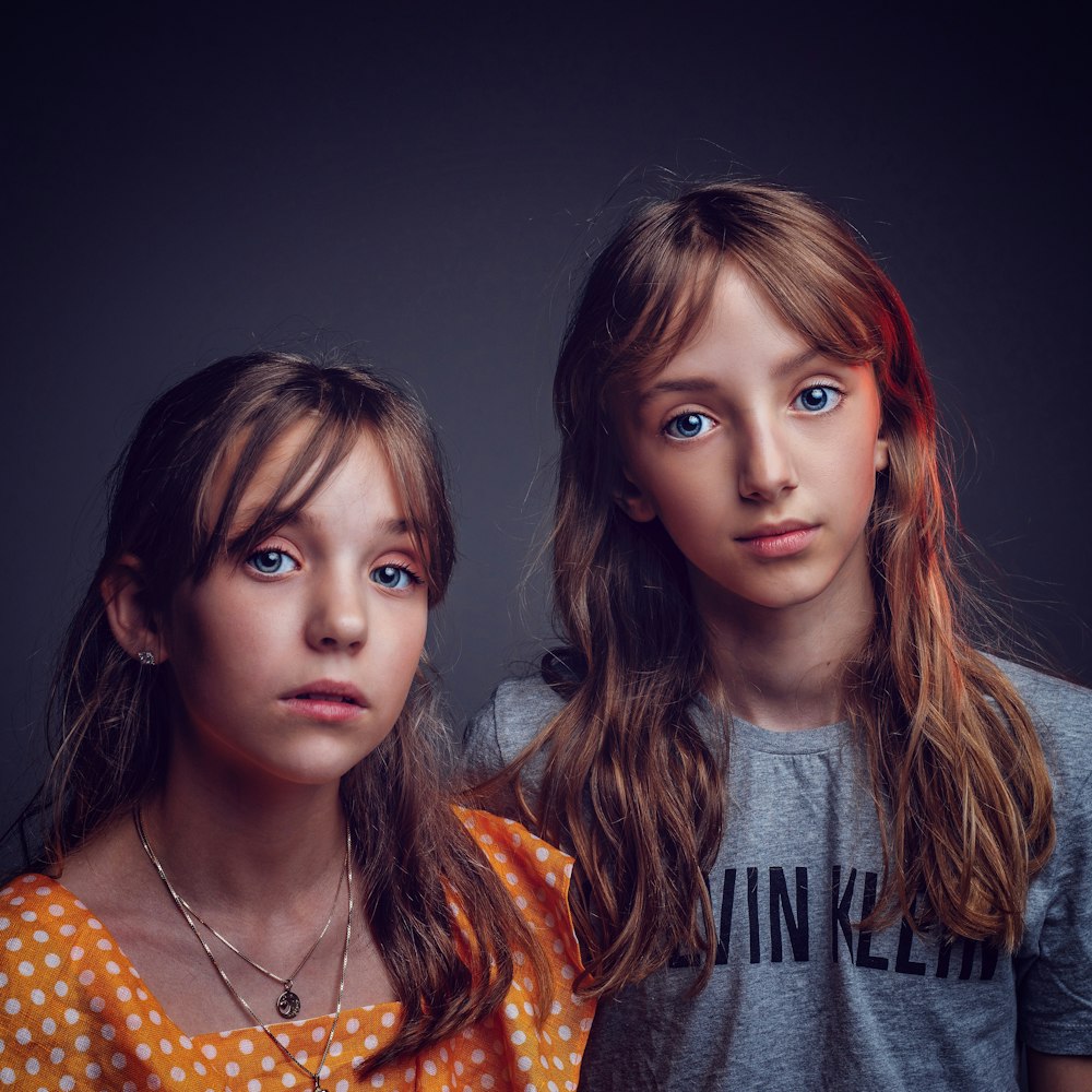 사진을 위해 포즈를 취하는 셔츠를 입은 두 소녀